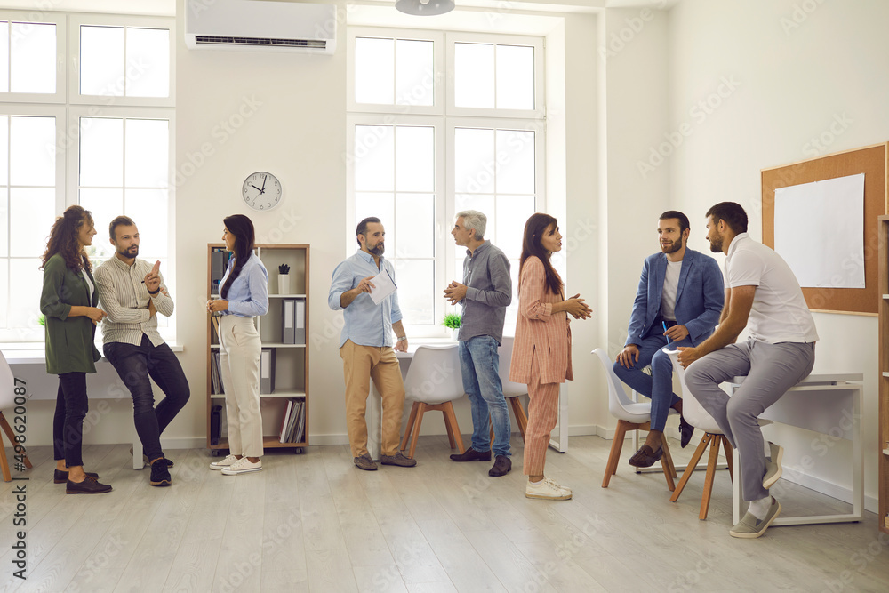 Groups of people gathering in modern spacious office during break at business conference or after company corporate meeting, talking, discussing speakers and making useful contacts for collaboration
