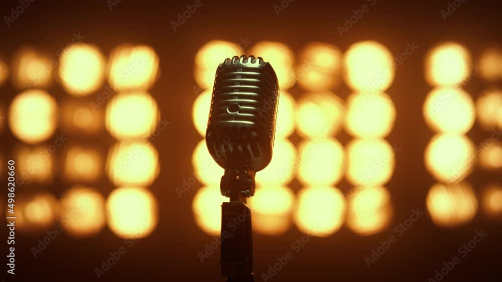 Retro mic placed empty scene illuminated lamps close up. Microphone in nightclub