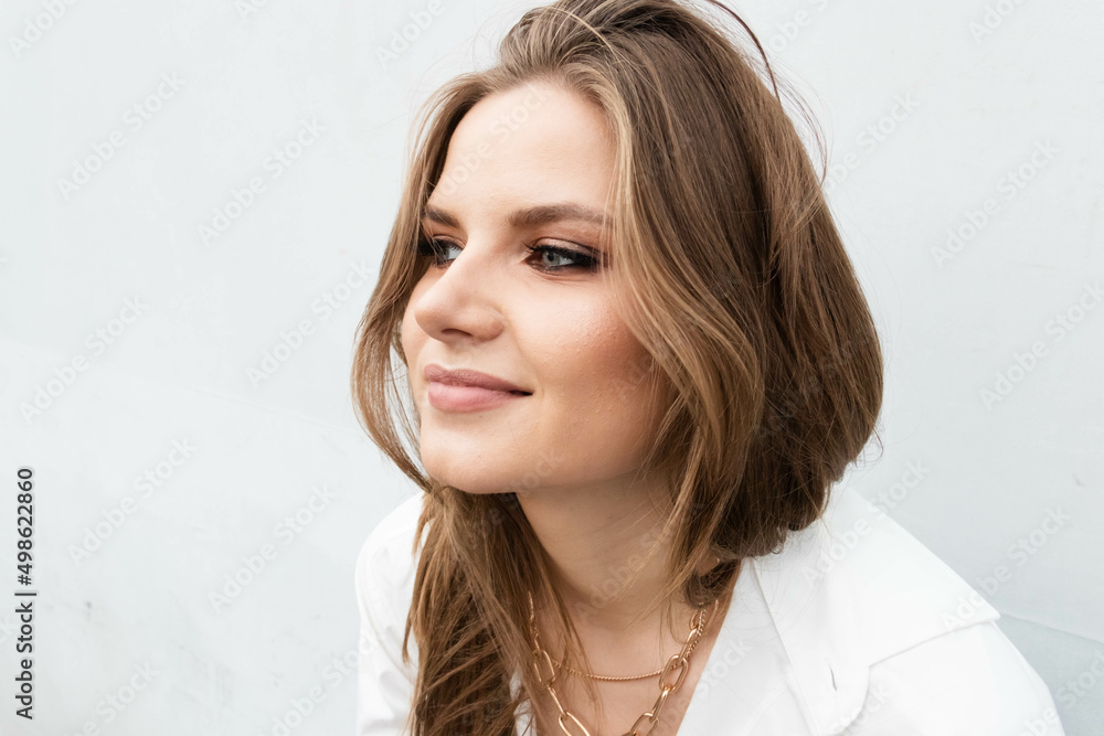 Fototapeta premium a girl in a white shirt is sitting at a white background