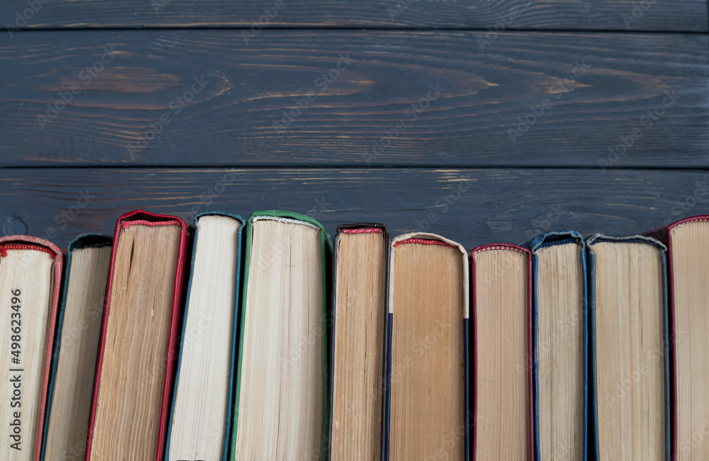 A stack of books on a gray wooden background. the concept of reading books on paper. A stack of books on a gray wooden background. the concept of reading books on paper.