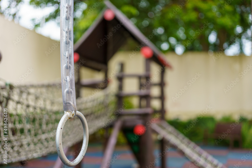 corrente com uma argola pendurada em primeiro plano e o fundo desfocado com alguns brinquedos para crianças corrente com uma argola pendurada em primeiro plano e o fundo desfocado com alguns brinquedos para crianças