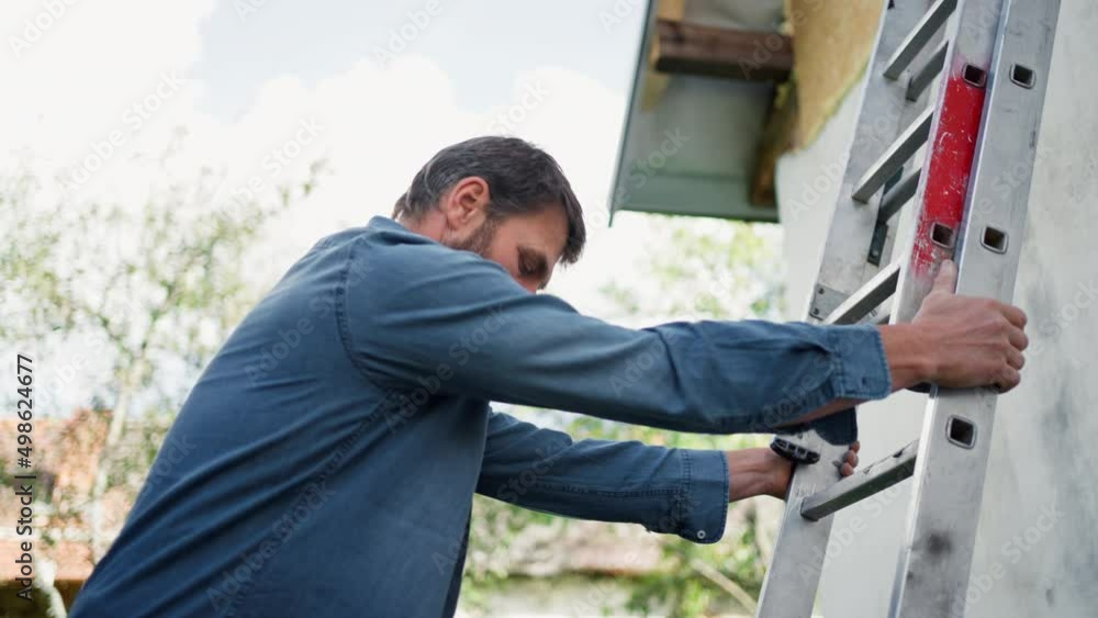 High angle view of mature man climbing up the ladder High angle view of mature man climbing up the ladder