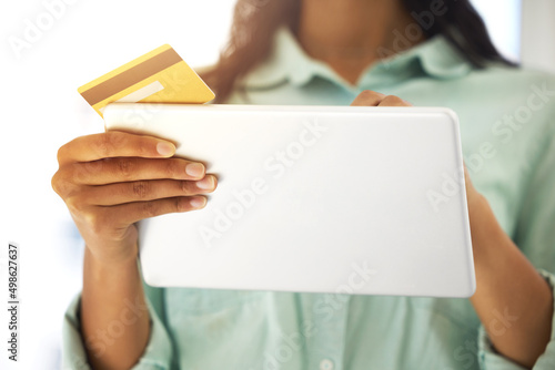 Need to make some quick payments. Cropped shot of an unrecognizable person using a credit card and a digital tablet to shop online at home.