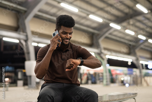 Portrait of handsome black man at train station during night