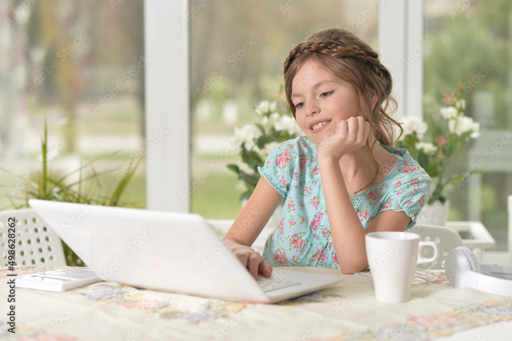 cute little girl using laptop at home