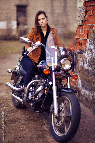 Portrait of beautiful young woman posing with motorcycle © aletia2011