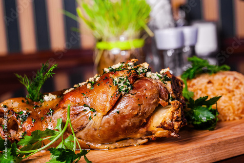 Canvas Print German style roasted pork hock (knuckle, shank) with rice on wooden cutting boar