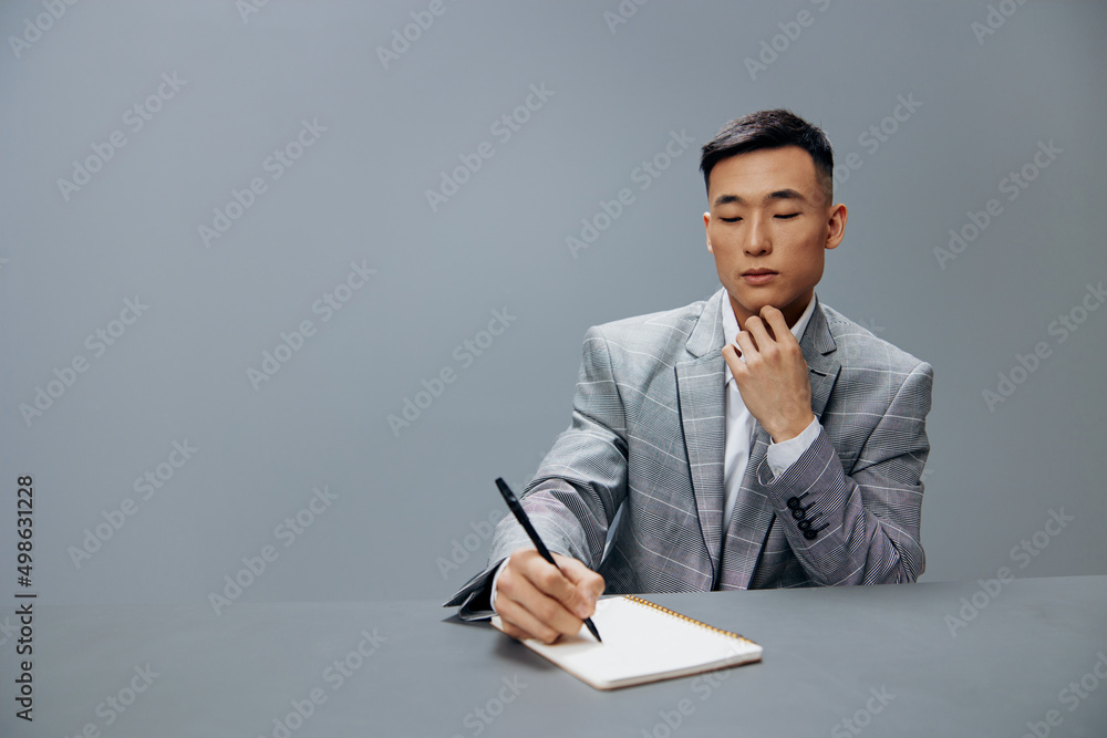 worker in a gray suit in the office with a notepad on the table the idea of writing Lifestyle worker in a gray suit in the office with a notepad on the table the idea of writing Lifestyle