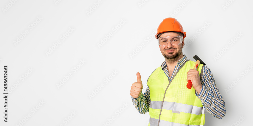 Construction worker with protective helmet holding hammer and showing his thump. White background Construction worker with protective helmet holding hammer and showing his thump. White background