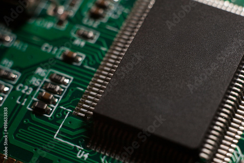 Macro photo of a green computer printed circuit board with selective focus on an blank chip