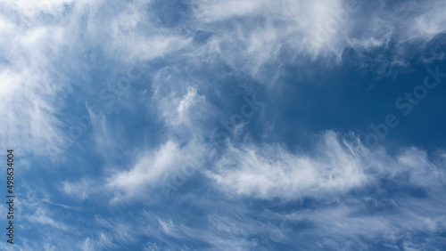 daytime blue sky with wind scattered white cirrus clouds as a natural backdrop