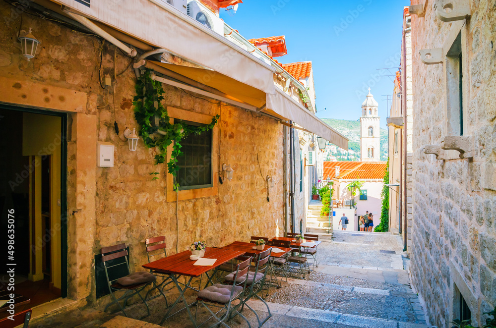 Famous narrow street and old city walls in Dubrovnik, Croatia
