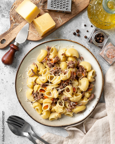 Obraz na płótnie Pasta Pipe Rigate with stew In Bianco in a plate on a gray culinary background. Traditional Italian pasta with ground beef on the kitchen table closeup w salonie