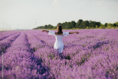 Fototapeta Naklejka Na Ścianę i Meble -  Free woman with open arms enjoying the moment in the lavender field in France. Harmony and people concept. 