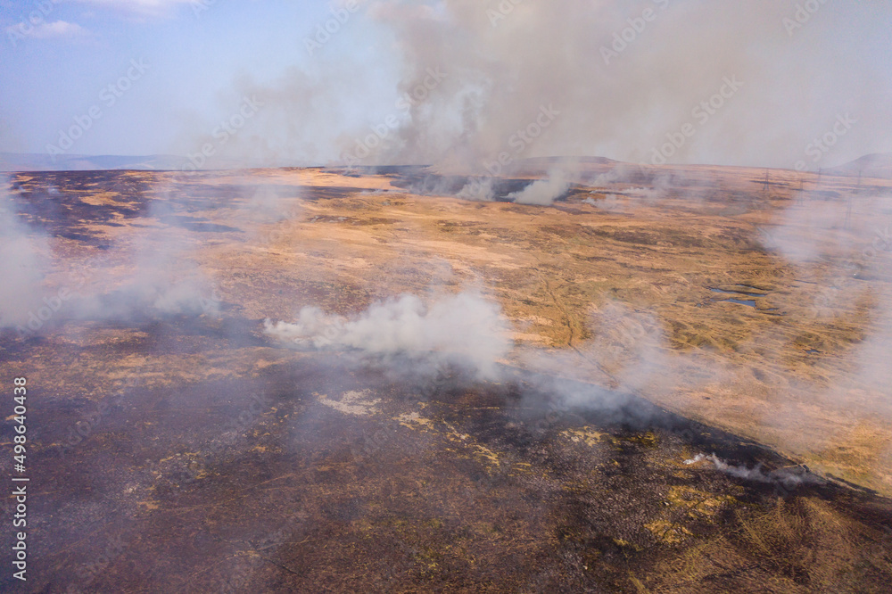Aerial view of smoke and flames from a large grassfire on moorland in South Wales, UK (Llangynidr Moors)