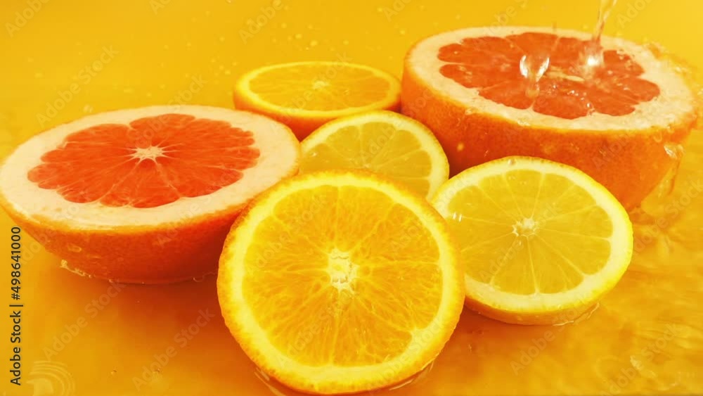 Slices of lemon, orange and grapefruit in a stream of water. Slow motion. Slices of lemon, orange and grapefruit in a stream of water. Slow motion.