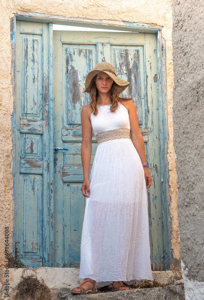 Young beautiful pretty white woman in Oil old town in Santorini greek island in Greece near blue door and white buildings in summer. High quality photo Young beautiful pretty white woman in Oil old town in Santorini greek island in Greece near blue door and white buildings in summer. High quality photo