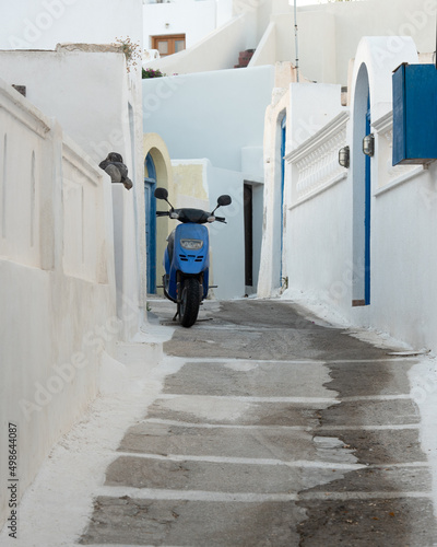 Blue moto in Santorini island in Greece near white buildings and blue doors and stairs. High quality photo © Anna Patagonia Photo
