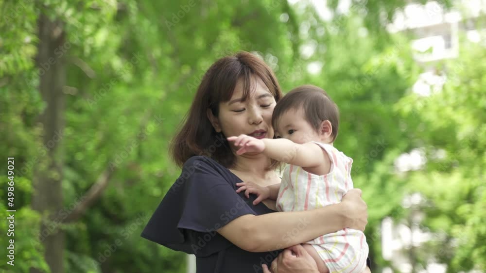 公園を散歩する赤ちゃんとお母さん