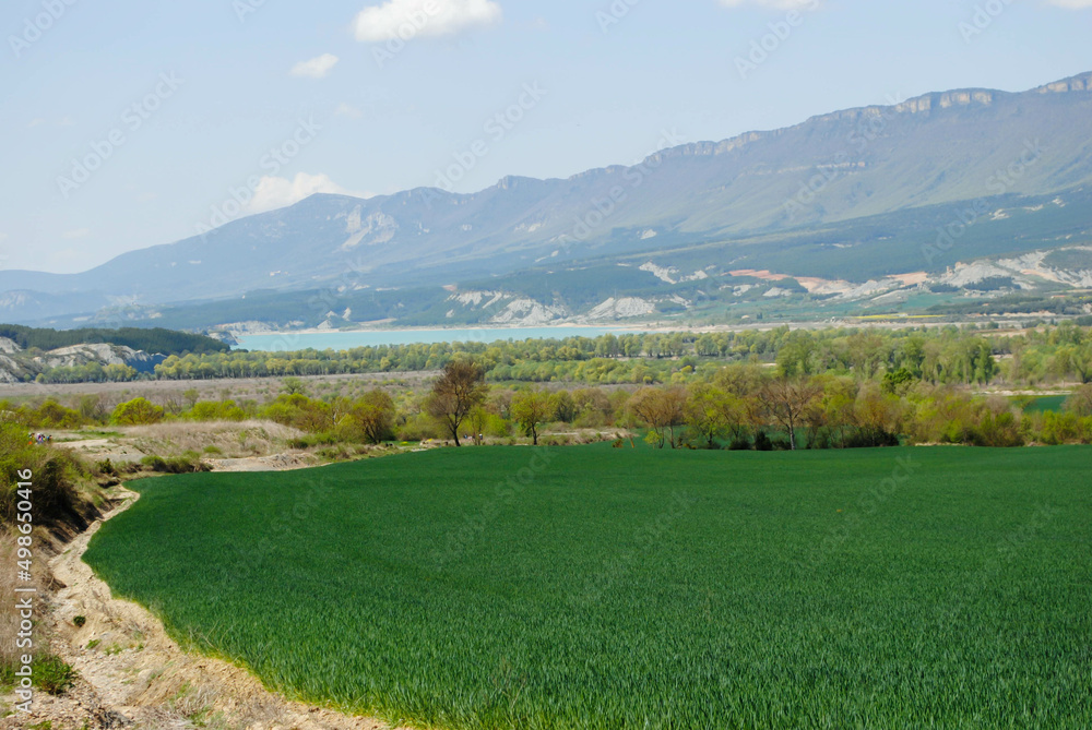 Plain of agricultural fields with clear blue sky over distant mountains
