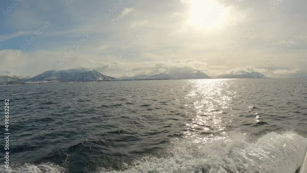 Panning shot from the front of a boat cruising over the sea with cloud draped mountains in the distance, Panning shot from the front of a boat cruising over the sea with cloud draped mountains in the distance,