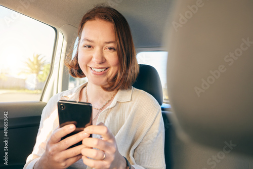 When life gives you wheels go see the world. Shot of a young woman using a smartphone while traveling in a car.