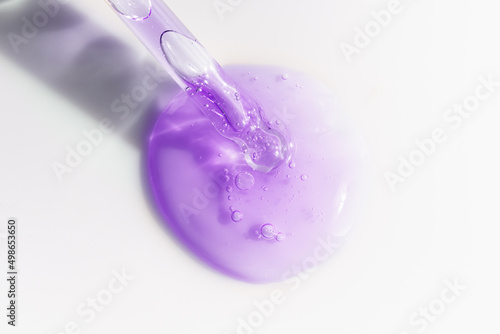 Bakuchiol serum transparent texture with pipette, purple liquid skincare cosmetic gel, macro