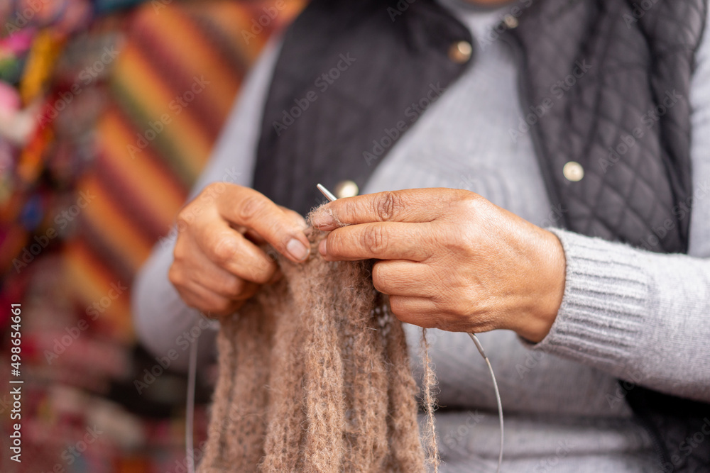 Hands weaving baby alpaca wool in a handicraft shop