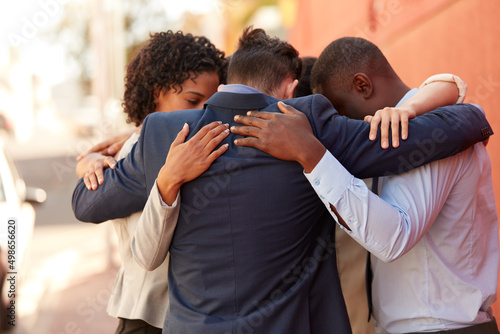 We draw support and motivation from each other. Shot of a group of businesspeople standing together in a huddle outdoors. © Daniel Laflor/peopleimages.com