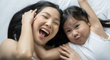 Asian mother and daughter smile and look at camera. Happy love family concept