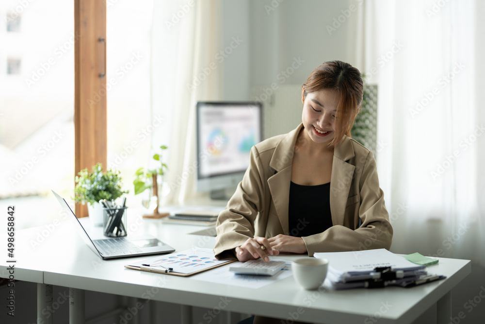 Attractive business asian women using calculator at working with financial report. Attractive business asian women using calculator at working with financial report.
