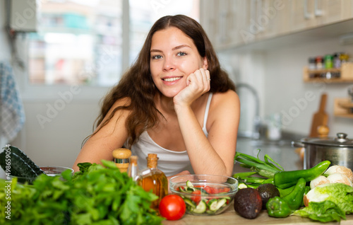 Portrait of cheerful caucasian woman standing at kitchen