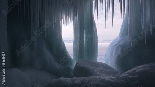 Huge stalactites, sharp icicles floes, frozen grotto blue ice, iceberg of lake Baikal. photo