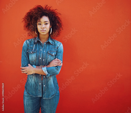 Im a denim kinda girl. Portrait of an attractive young woman posing against a red background. photo