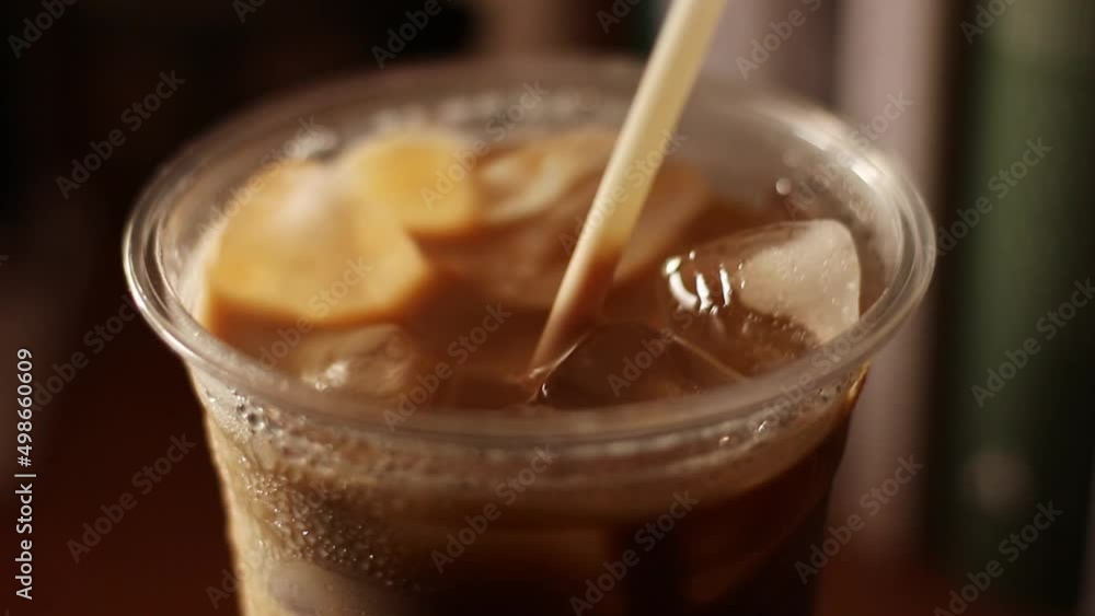 Close up iced coffee in plastic glass and white tube Close up iced coffee in plastic glass and white tube
