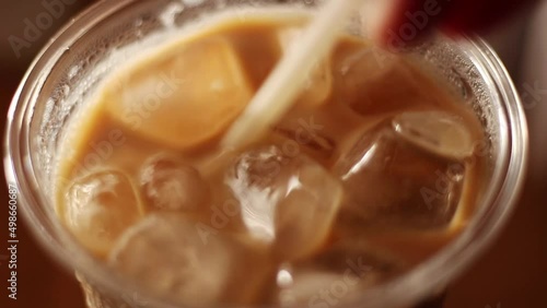 Close up iced coffee in plastic glass and white tube