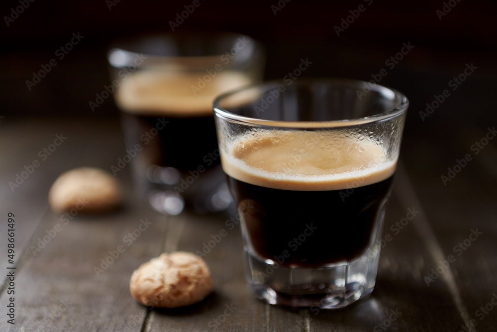 Two Glasses Of Coffee with Amaretti (Italian biscuits) on dark wooden background. Close up. Two Glasses Of Coffee with Amaretti (Italian biscuits) on dark wooden background. Close up.
