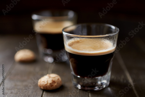 Two Glasses Of Coffee with Amaretti (Italian biscuits) on dark wooden background. Close up. 