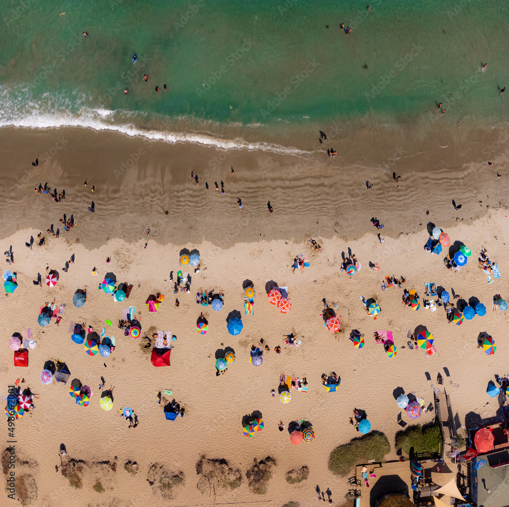 Colorido paisaje en playa. Verano para disfrutar arena, sol, mar y calor. Sombrillas playeras desde drone. Colorido paisaje en playa. Verano para disfrutar arena, sol, mar y calor. Sombrillas playeras desde drone.