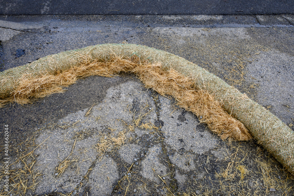 Straw containment barrier on the driveway of a residential construction