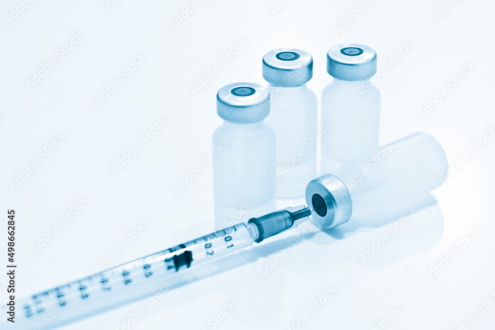 Vial of Drugs and 1 ml Plastic Syringe with Needle Isolated on the White Background Vial of Drugs and 1 ml Plastic Syringe with Needle Isolated on the White Background