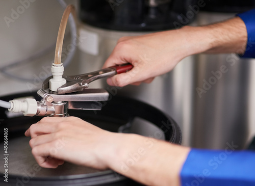 Skilled hands working on your water heating system. Cropped shot of a handyman repairing a pipe on a water heater.