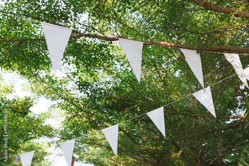 white triangle flags are hanging on tree branches. concept   decoration for party. .