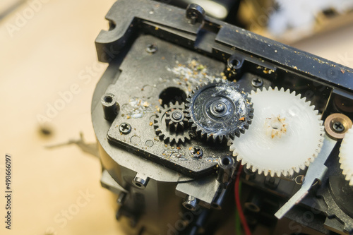 A group of gears of a compact camera to be repaired. Cleaning the gears inside the electronics. Camera repair. Selective focus