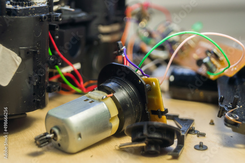 Compact electric motor. Repair of consumer electronics. Workflow in the workshop of electrical appliances. Electronic components and parts disassembled. Selective focus, background