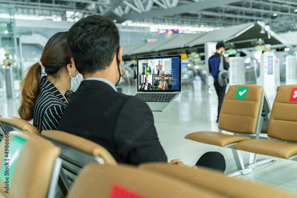 Businesswoman and Business team in video conference for protection covid-19 and online meeting during airline flight status at terminal airport.Webinar,social distancing and seminar online Concept. 