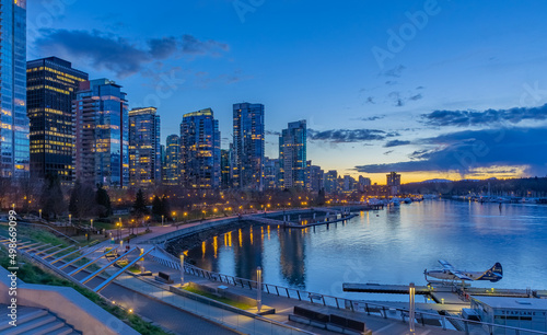 Night scene of modern buildings in Vancouver downtown. Long exposure of waterfront. Colorful city night with skyscrapers