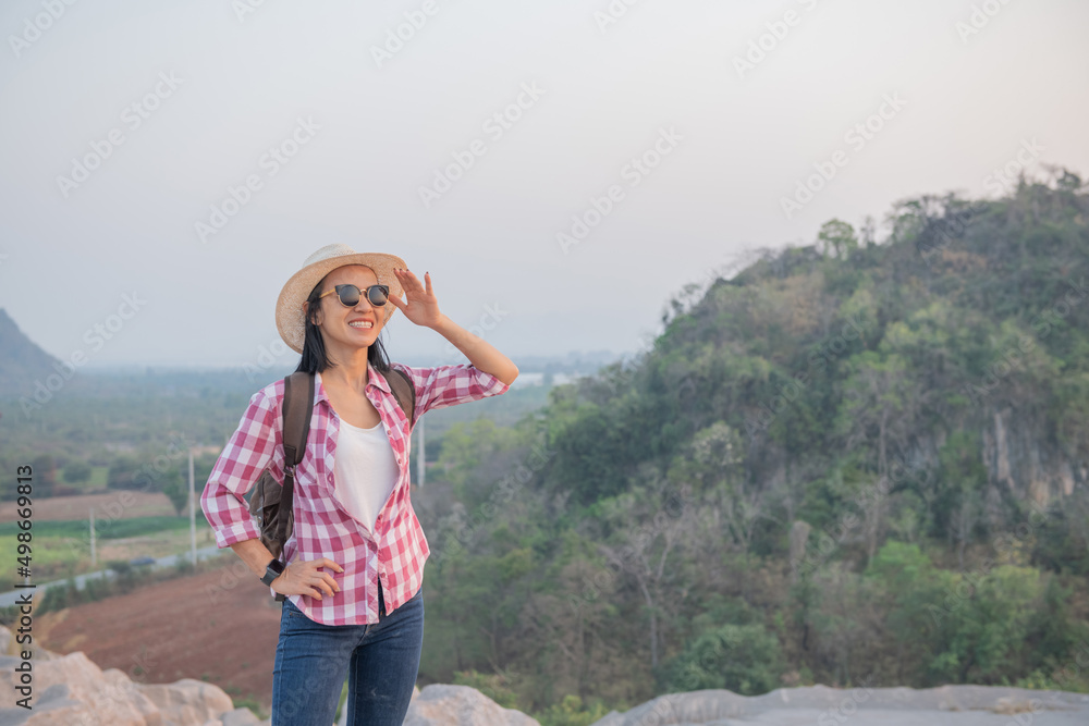 Hiker with backpack standing on top of a mountain and enjoying stunning valley view. adventure travel, camping and hiking in nature. concept adventure summer vacations outdoor mountaineering sport.