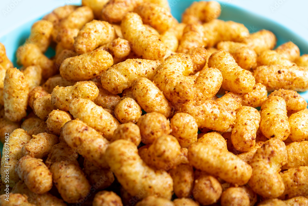 Puffed corn peanuts snacks on plate. Close-up. Puffed corn peanuts snacks on plate. Close-up.