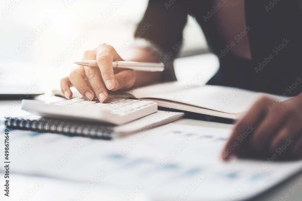 Close up Business woman hand using calculator to calculate the company's financial results and budget. Account Audit Concept. Close up Business woman hand using calculator to calculate the company's financial results and budget. Account Audit Concept.